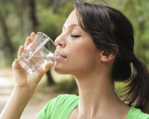 Девушка пьет воду из стакана
