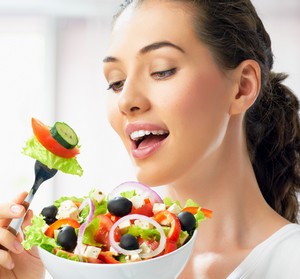 Женщина ест овощной салат