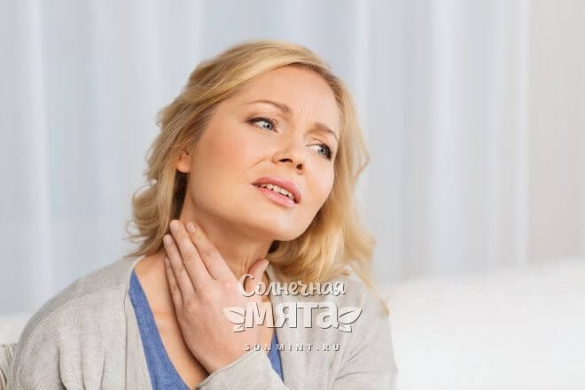 Обеспокоенная женщина проверяет свою щитовидку, фото